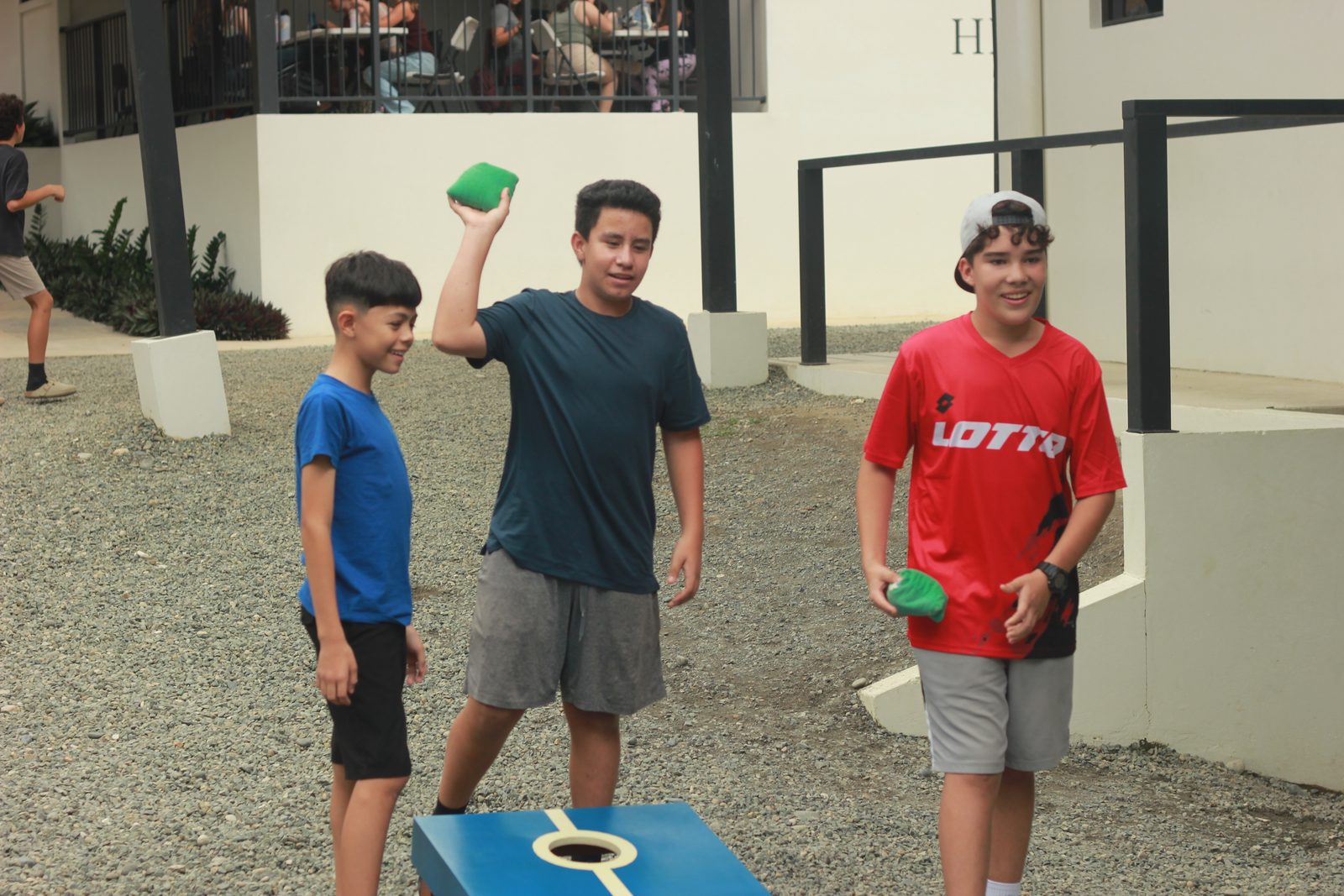 Students tossing bean bags in a cornhole game on campus grounds