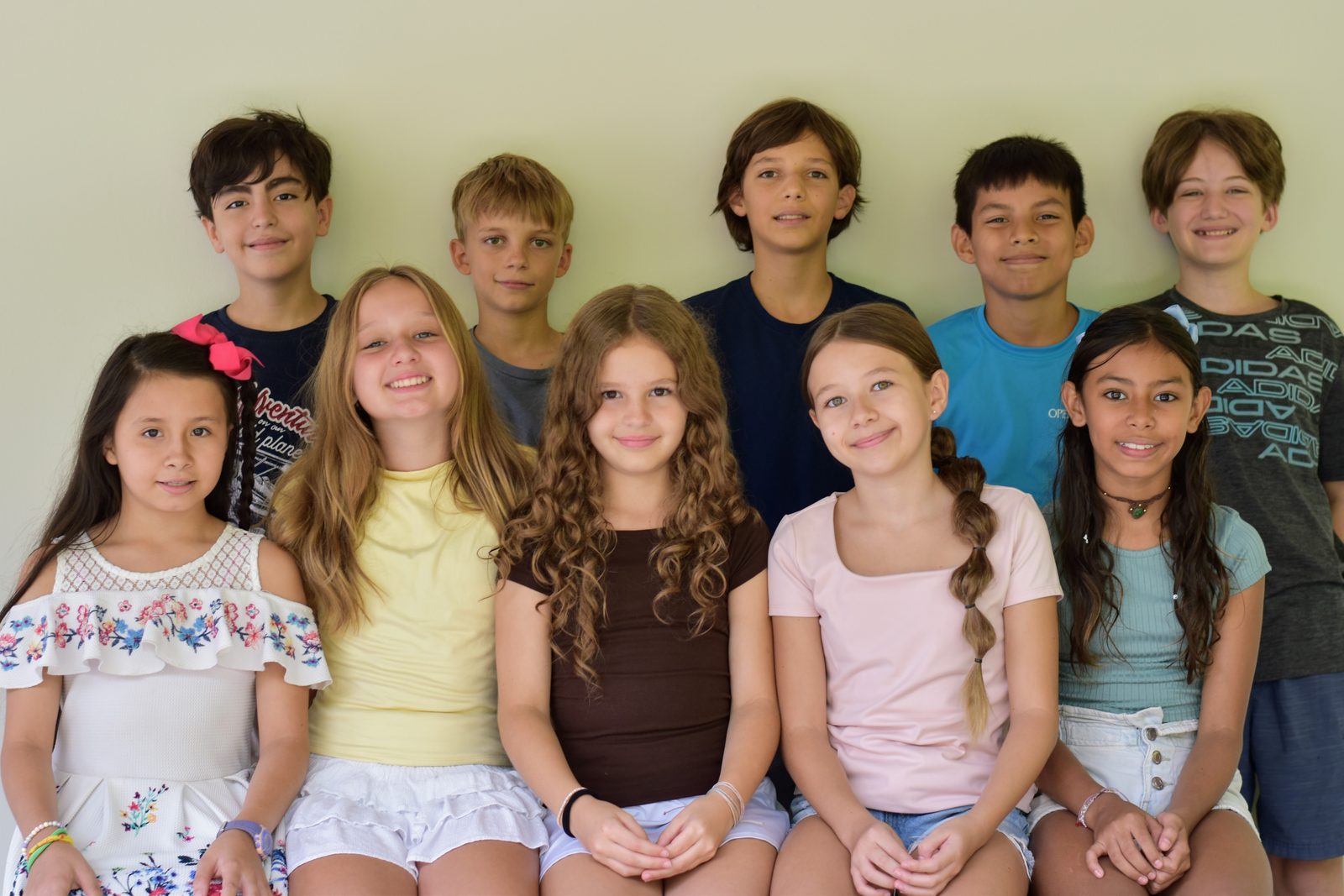 Group photo of children arranged in two rows, smiling at the camera
