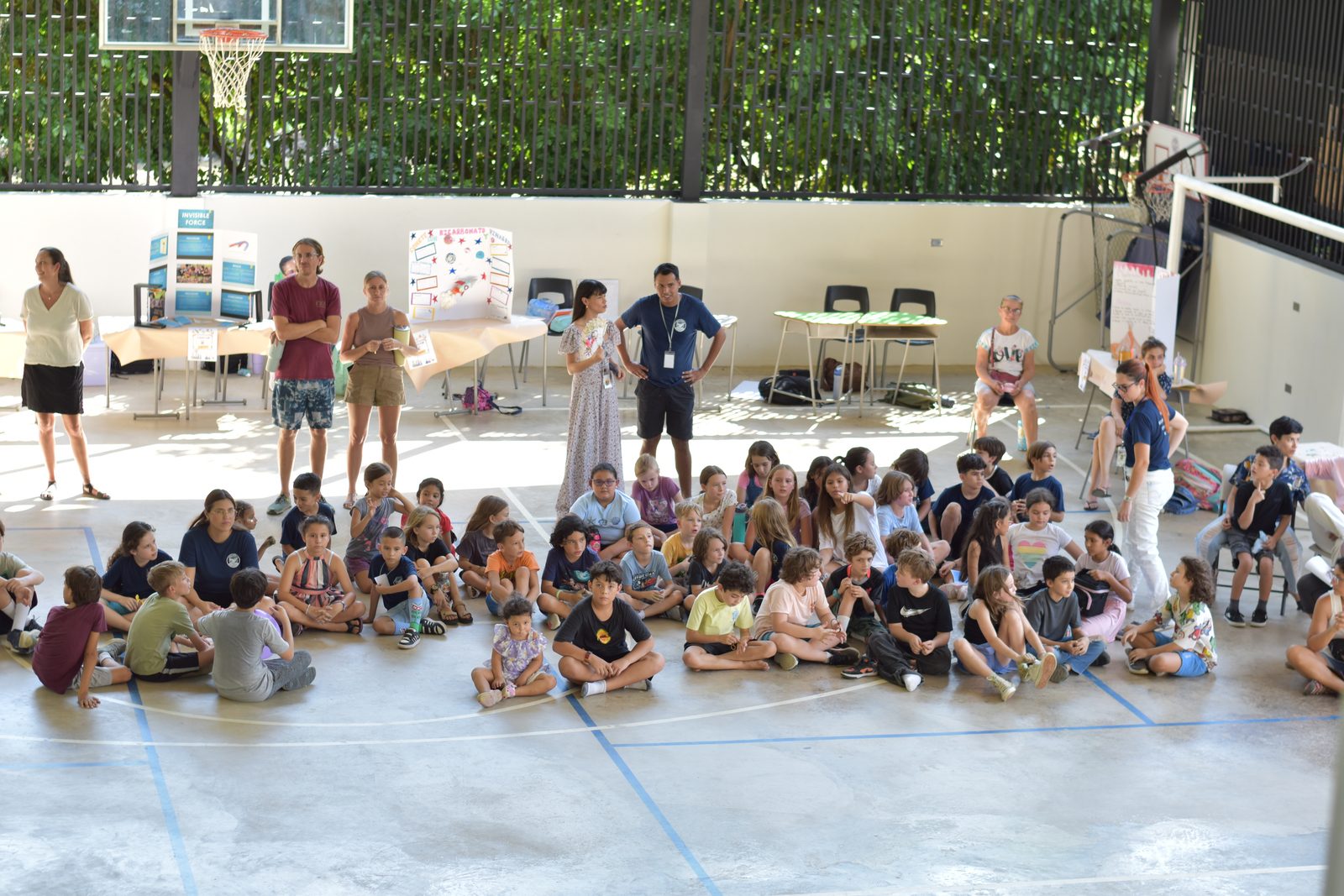 Large school assembly gathered in gymnasium with students seated and teachers facilitating activity