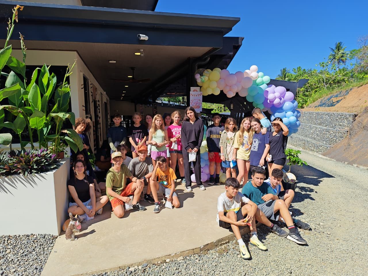 Group of Ballena Academy students pose together in front of school building