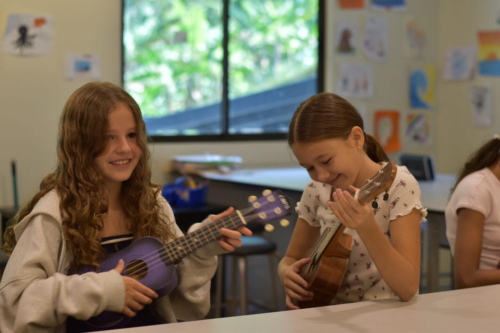 Two young students playing guitars together during music class