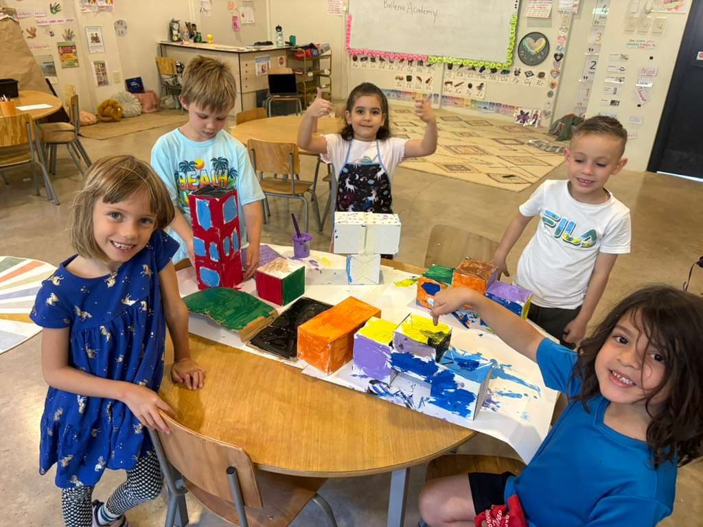 Preschool students display their colorful painted artwork in classroom