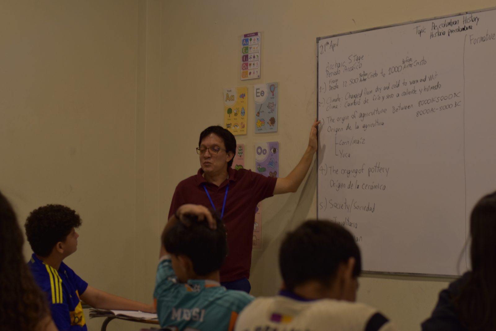 Teacher explains Spanish lesson to elementary students at whiteboard