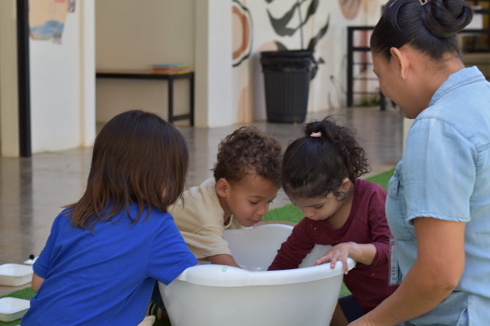 Children and teacher explore materials together in hands-on activity